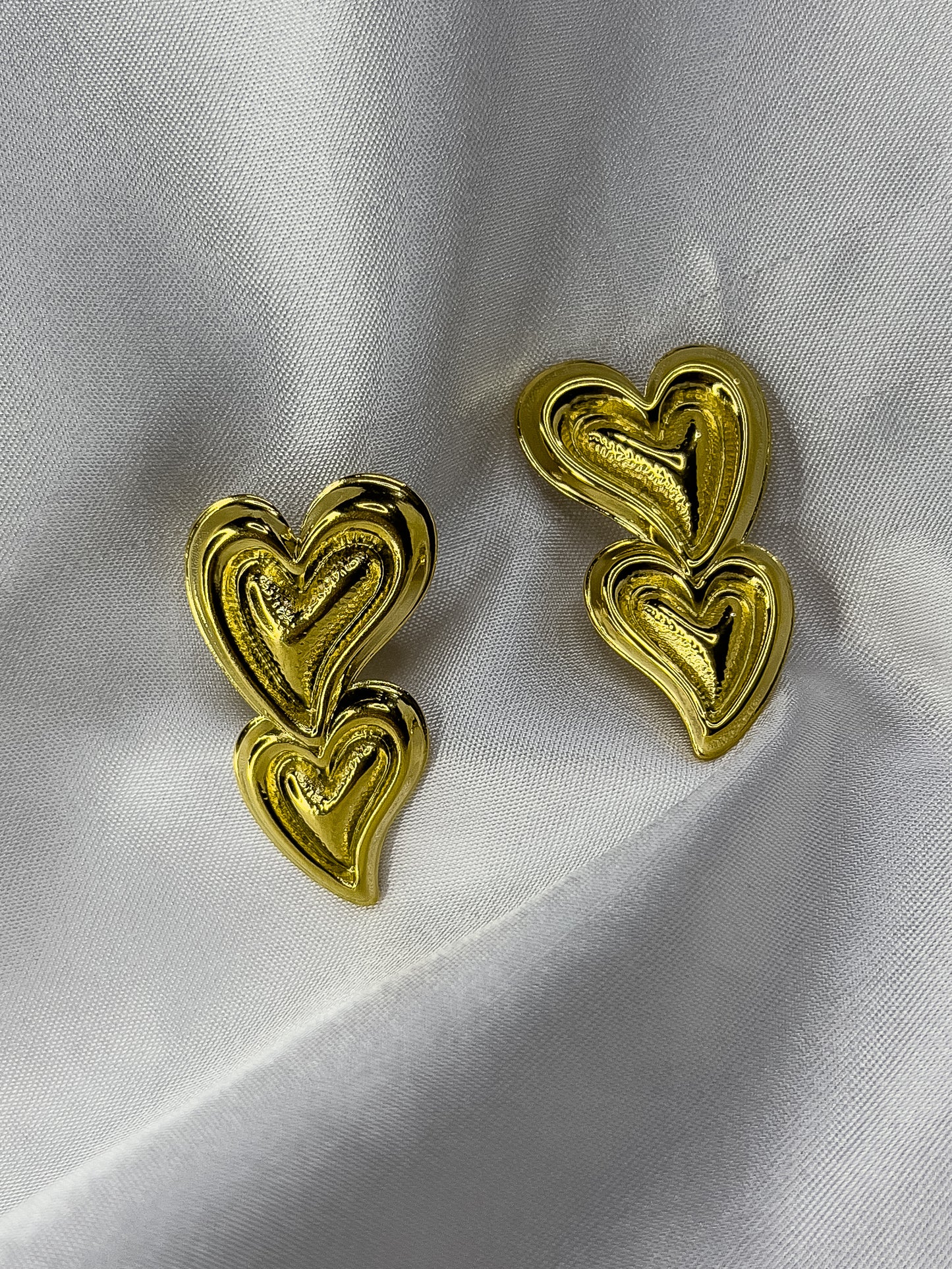 aretes de dos corazones dorados